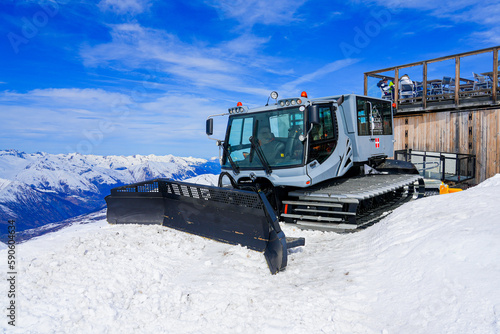 Les Ménuires, France - March 16, 2023 : Grey snow groomer on a snowy mountaintop in Les Ménuires ski resort in the French Alps