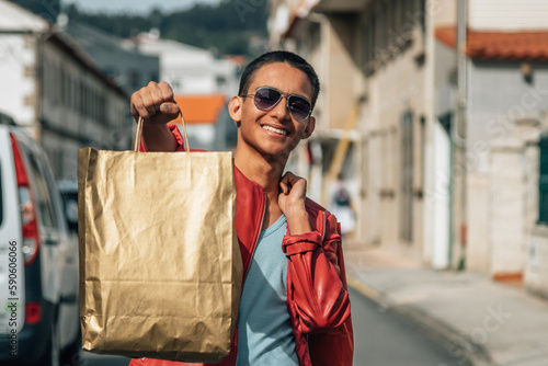 happy young man shopping street with bags