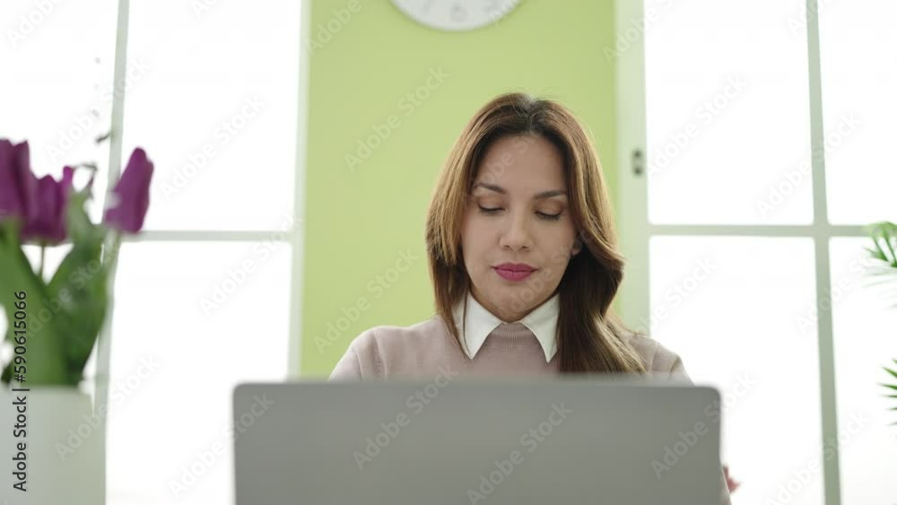 Young beautiful hispanic woman using laptop relaxed on table at home Young beautiful hispanic woman using laptop relaxed on table at home