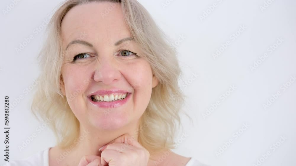 I choose you beautiful middle-aged woman with two hands with index fingers points at us to camera smile close eyes on white background blonde face bite lower lip smile joy space for ad text