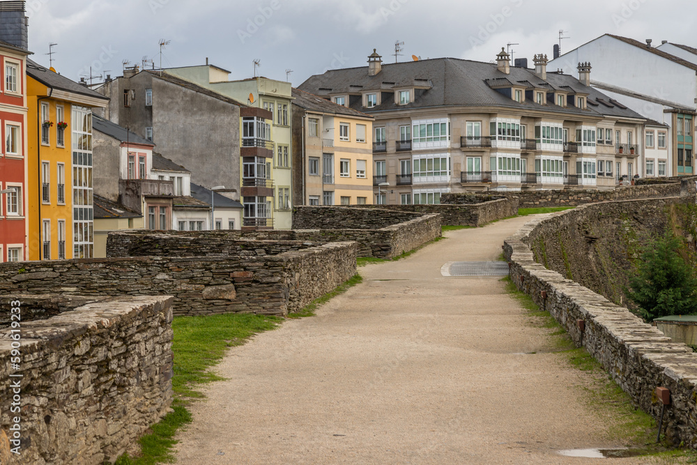 Exposure from the Lugo city Walls, from where you can see the surrounding modern buildings, old gates and towers of this fortifications located in this Spanish city.