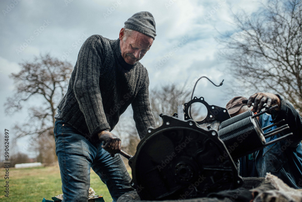 tractor car engine repair at home, old man repairs the engine. tractor car engine repair at home, old man repairs the engine.