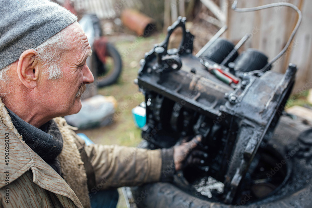 tractor car engine repair at home, old man repairs the engine. tractor car engine repair at home, old man repairs the engine.
