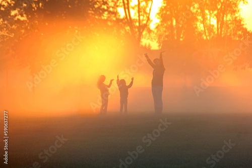 Family playing in the early morning fog