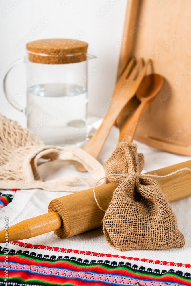 a jug of water and wooden kitchen utensils with string bag and wooden tray a jug of water and wooden kitchen utensils with string bag and wooden tray