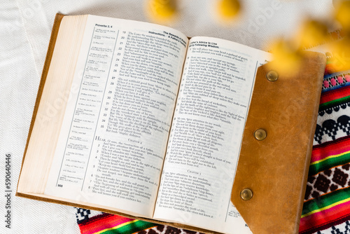 an old shabby Bible in brown leather cover open on linen embroidered towel