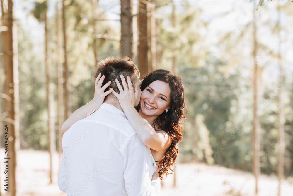 Young happy couple in love hugging smiling and having fun in the mountains. High quality photo. A girl in a beautiful white dress Young happy couple in love hugging smiling and having fun in the mountains. High quality photo. A girl in a beautiful white dress
