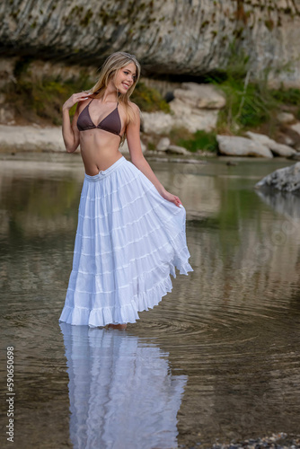 A Lovely Blonde Bikini Model Enjoys The Summer Weather On A Lake