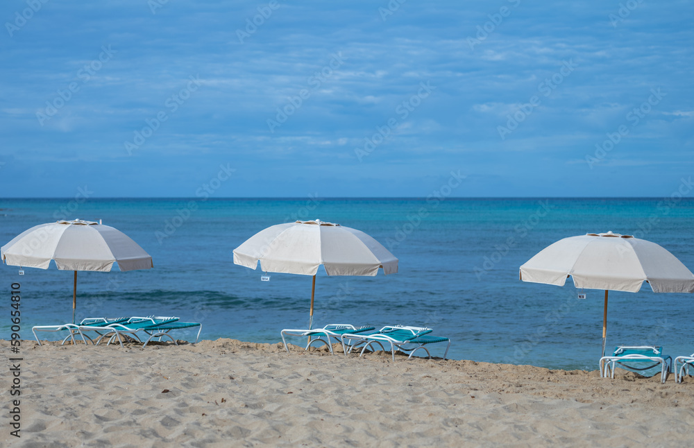Three Tan Beach Umbrellas under Blue Sky.