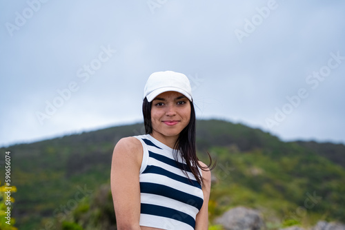 Mujer latina feliz viendo a cámara con montaña de fondo