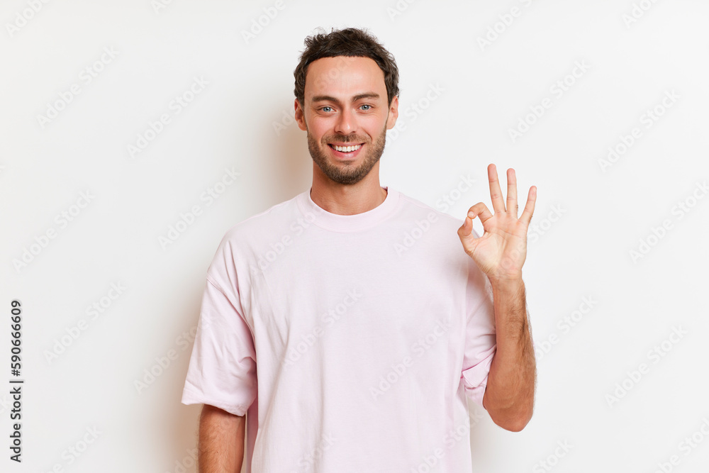 Portrait of smiling guy with beard posing against white background, showing OK sign with fingers, perfect mood concept, copy space, high quality photo Portrait of smiling guy with beard posing against white background, showing OK sign with fingers, perfect mood concept, copy space, high quality photo