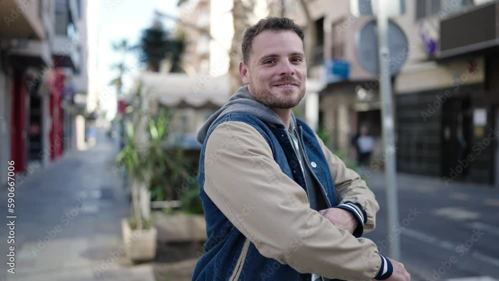 Young caucasian man smiling with crossed arms at street Young caucasian man smiling with crossed arms at street