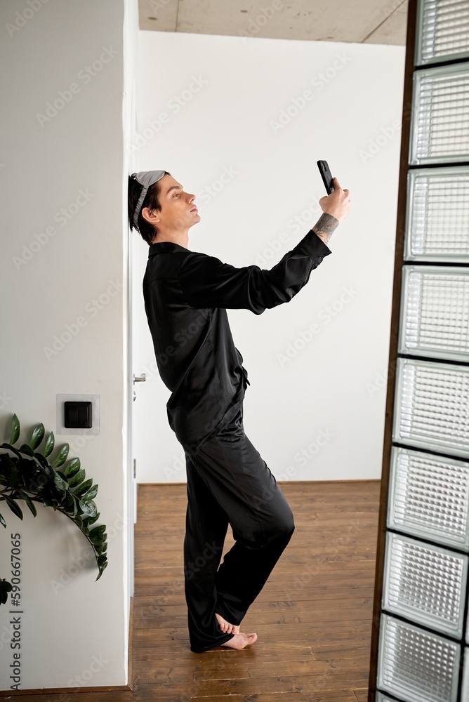 attractive brunette guy looking for wi-fi, internet conncection at home, full length side view shot, blogger spending time with phone, guy shoots film, video attractive brunette guy looking for wi-fi, internet conncection at home, full length side view shot, blogger spending time with phone, guy shoots film, video