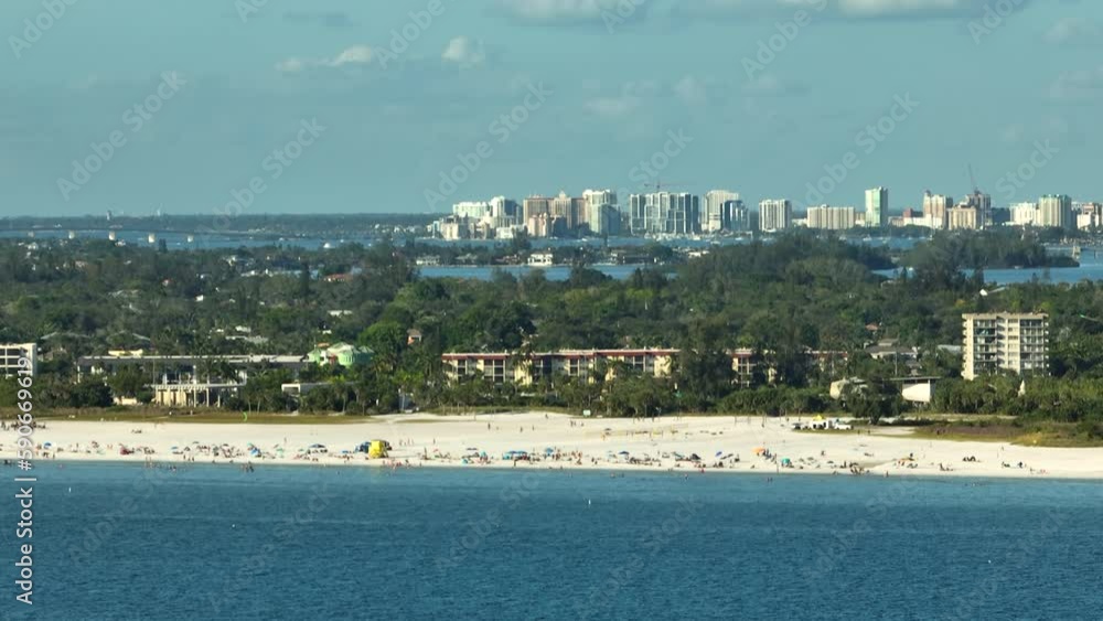 Famous Siesta Key beach with soft white sand in Sarasota, USA. Many people enjoing vacation time bathing in warm gulf water and tanning under hot Florida sun Famous Siesta Key beach with soft white sand in Sarasota, USA. Many people enjoing vacation time bathing in warm gulf water and tanning under hot Florida sun