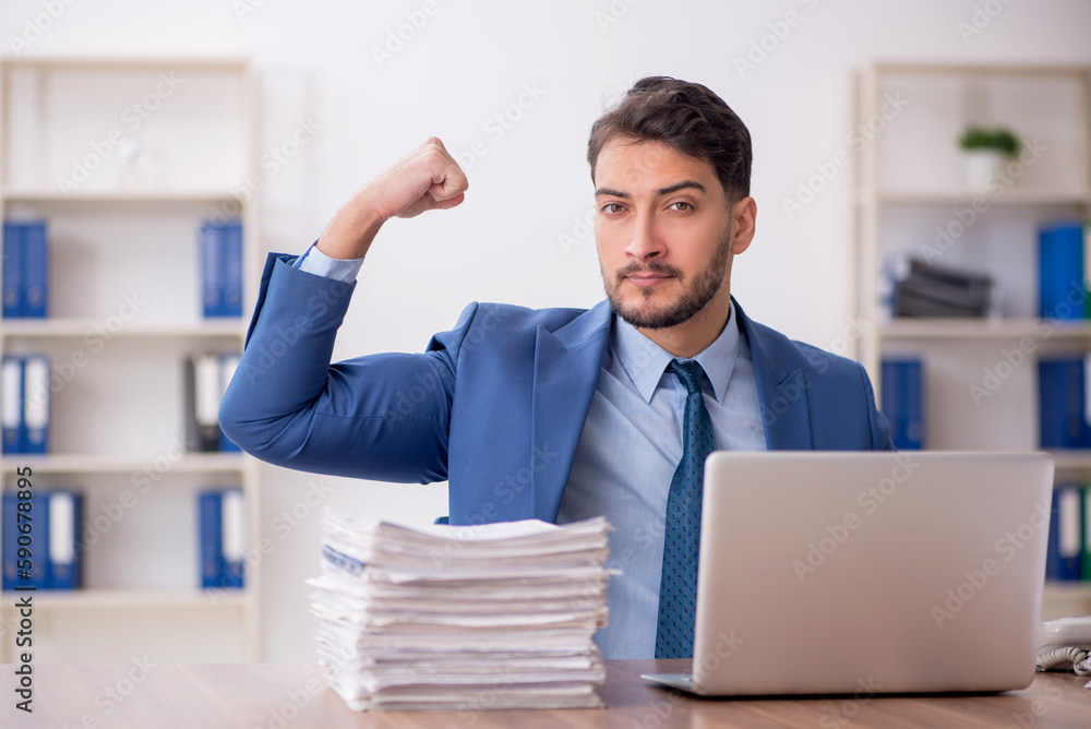 Young male employee and too much work in the office Young male employee and too much work in the office
