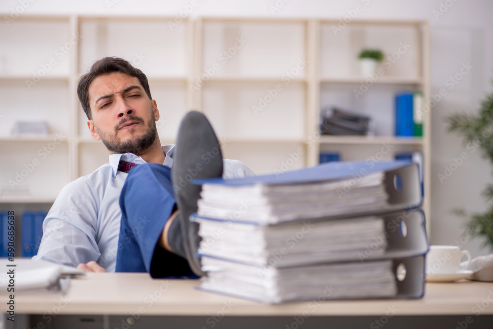 Young male employee sitting at workplace Young male employee sitting at workplace