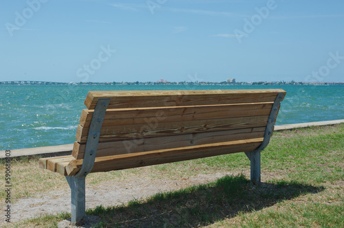 Back View of Park Bench looking out over bay water empty no people. Room for copy. © Del Harper