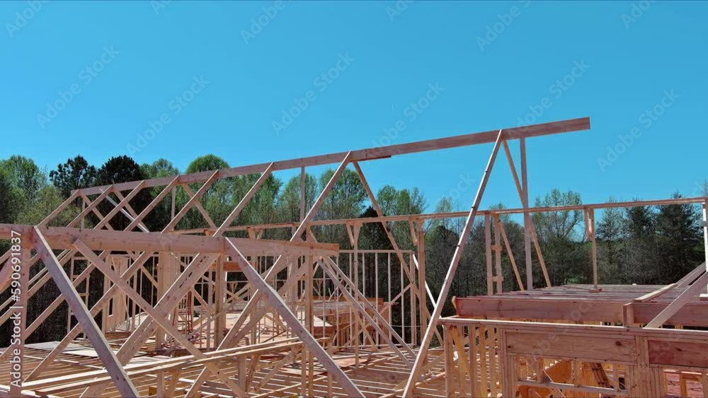 In progress construction of timber truss framed building with rafters, roof beams wooden joists In progress construction of timber truss framed building with rafters, roof beams wooden joists