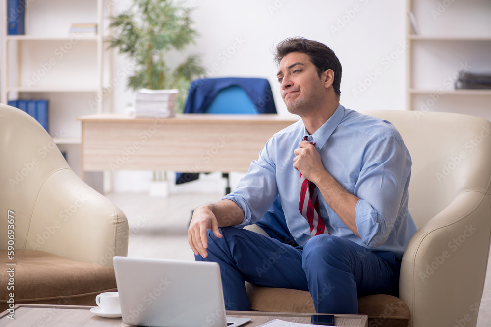 Young male employee sitting in the office Young male employee sitting in the office