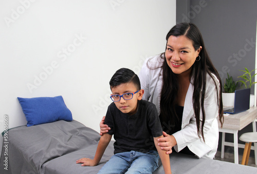 Latina doctor and boy patient with autism spectrum disorder, a developmental disability caused by differences in the brain. Some children with ASD have a genetic condition. photo