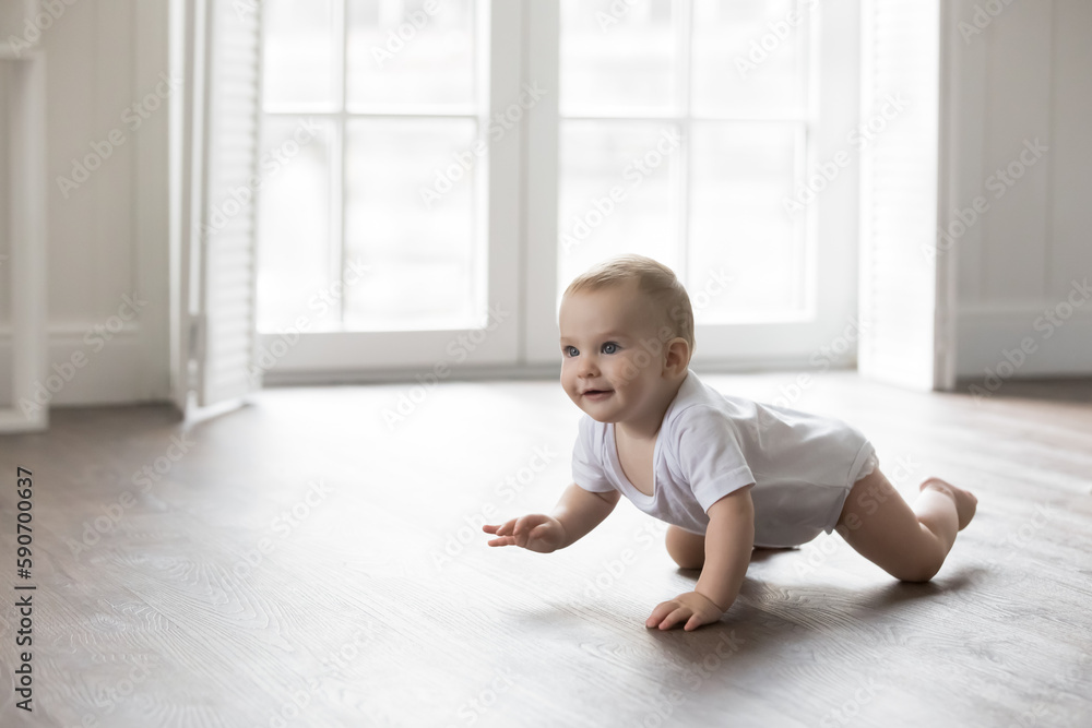 Happy baby in bodysuit crawling on knees on clean warm floor. Cheerful active little infant kid training physical skills, looking away, smiling. Pretty adorable infant kid home portrait Happy baby in bodysuit crawling on knees on clean warm floor. Cheerful active little infant kid training physical skills, looking away, smiling. Pretty adorable infant kid home portrait