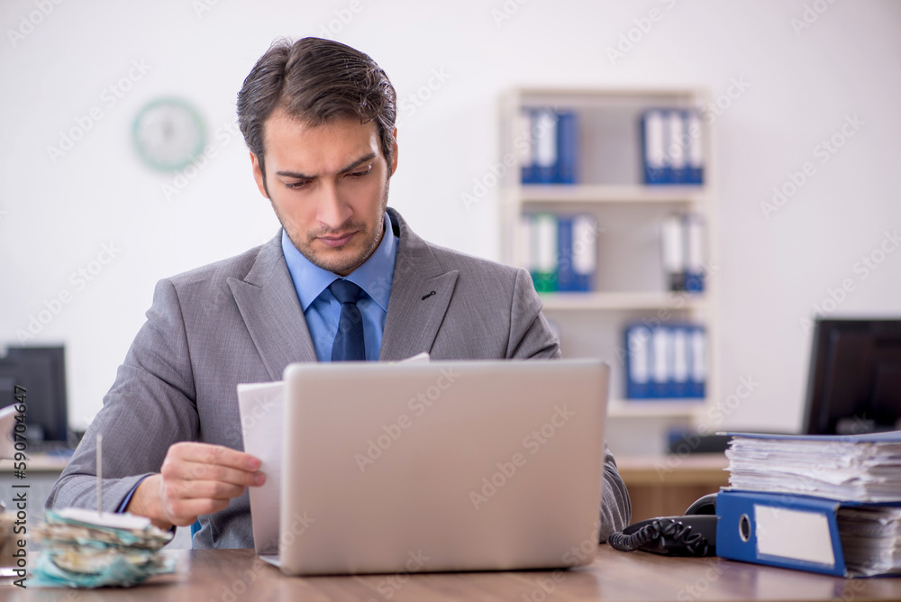 Young male employee working in the office Young male employee working in the office