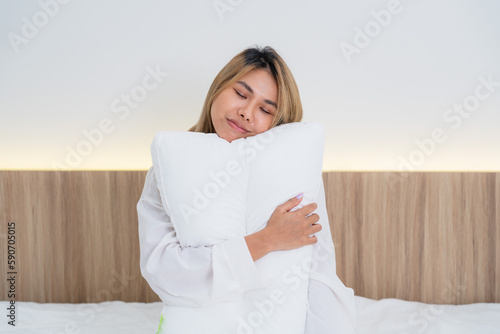 cute asian girl funny on bed with pillow