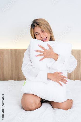 cute asian girl funny on bed with pillow