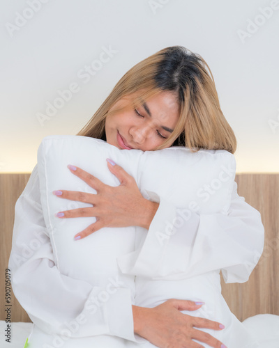 cute asian girl funny on bed with pillow