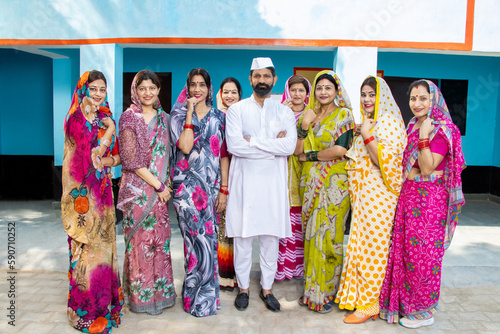 Indian man politician standing along with group of traditional women. Concept of politics and social worker.