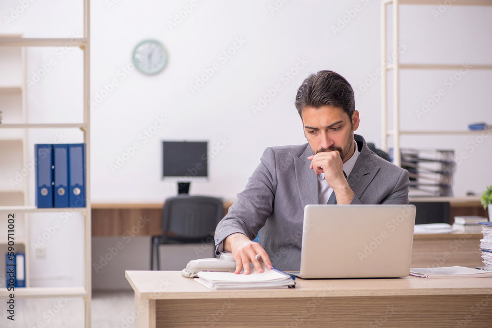 Young male employee working in the office Young male employee working in the office