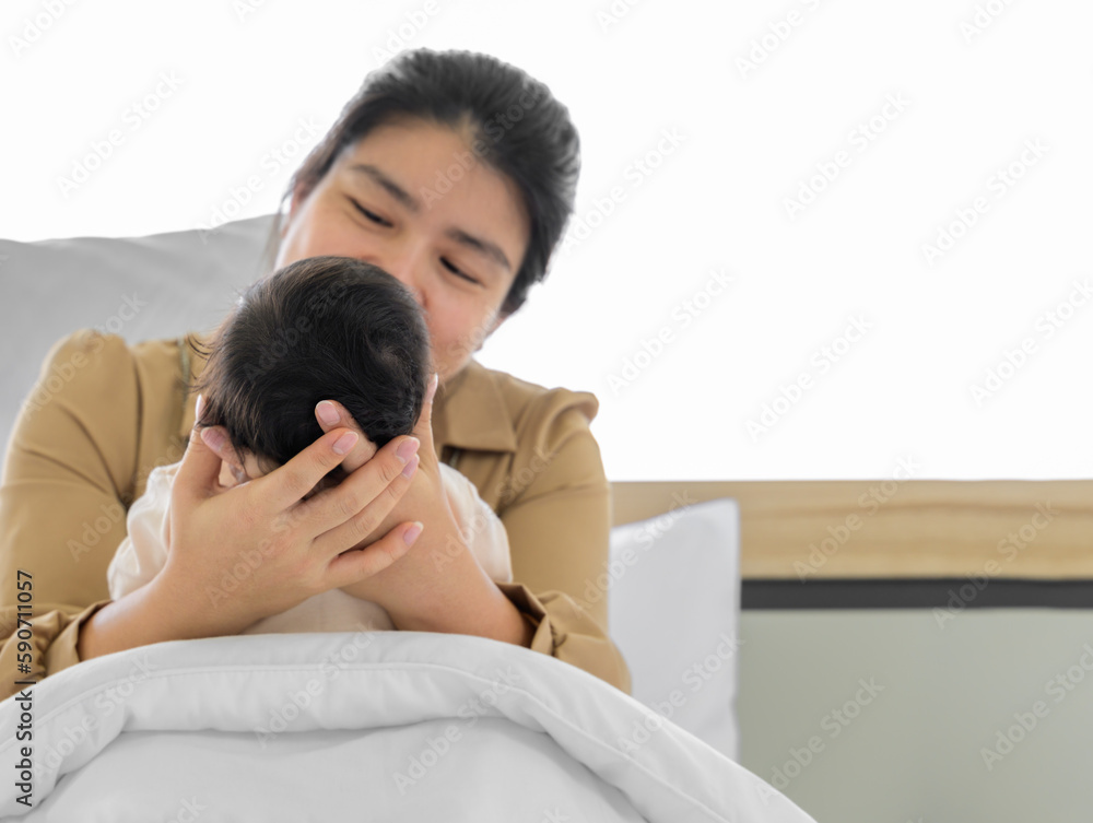 Mother holding head of her newborn baby girl or boy in hands. Loving mum sitting in white bed and holding infant child. Mother holding head of her newborn baby girl or boy in hands. Loving mum sitting in white bed and holding infant child.