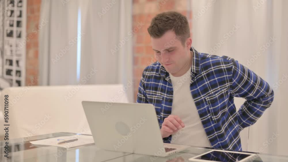 Young Casual Man with Back Pain Working on Laptop Young Casual Man with Back Pain Working on Laptop