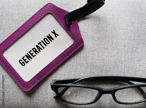 Purple ID card and reading glasses with text GENERATION X, concept of demographic group people who born 1965-1979 now in midlife 40-56 yrs old, prefer work life balance and still digitally savvy photo