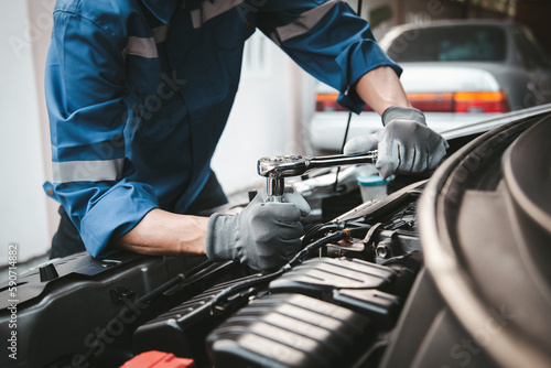 Car care maintenance and servicing, Hand technician auto mechanic using the wrench to fix car or repairing change spare part engine problem and insurance service support the range of car check. © Eakrin