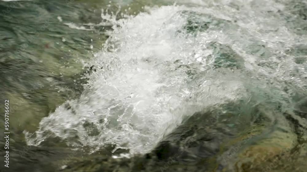 A beautiful view of flowing river water in the mountains. A stream of clear water with splashing water. Close up of abundant flowing water, near the river bank in slow motion A beautiful view of flowing river water in the mountains. A stream of clear water with splashing water. Close up of abundant flowing water, near the river bank in slow motion
