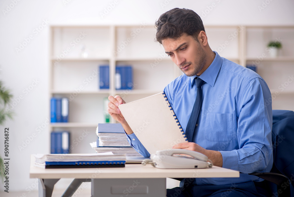 Young male employee working in the office Young male employee working in the office