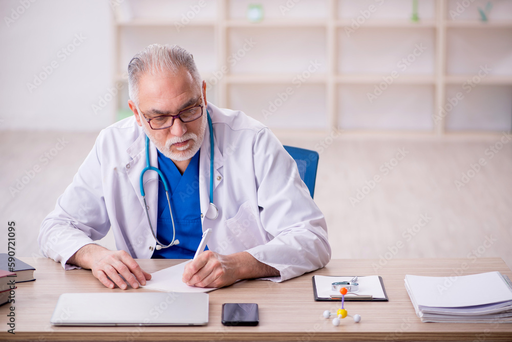 Old male doctor working in the clinic Old male doctor working in the clinic