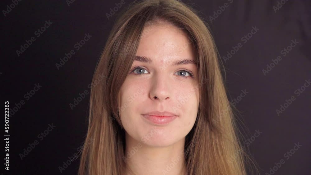 Portrait of a smiling young woman looking into the camera Portrait of a smiling young woman looking into the camera