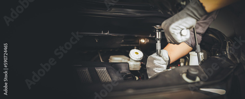 Close-up hand auto mechanic using the wrench to repairing car engine problem. Concepts of check and fix car and maintenance servicing.