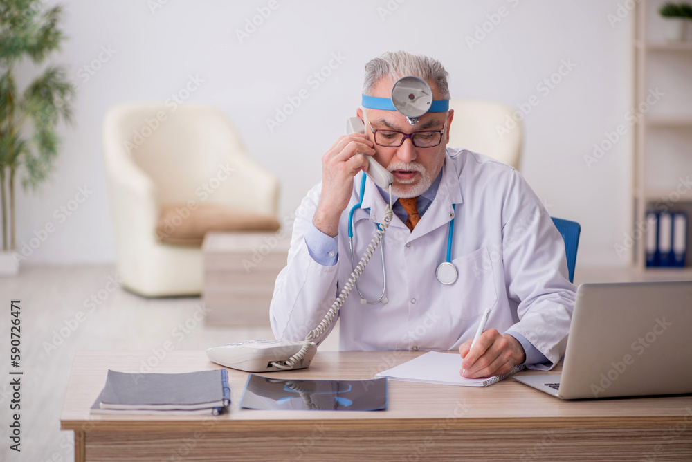 Fototapeta premium Old male doctor otologist working in the clinic