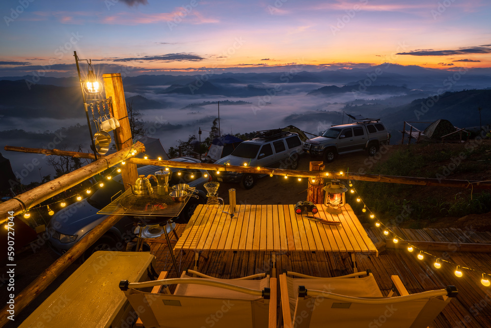 Table Stove and chair in camping  and tent with sunrise and fog on the mountain