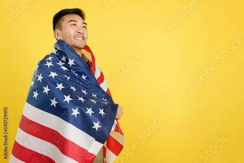 Proud chinese man wrapping with a USA national flag