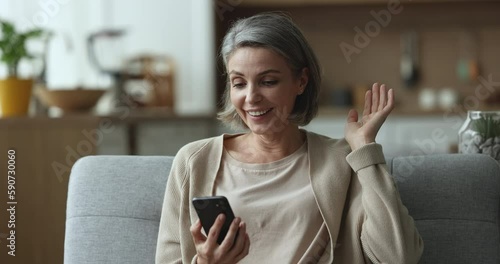 Serious engaged middle aged woman using online application on mobile phone, receiving surprising good news, celebrating success, win, money prize, getting positive, cheerful excited, happy