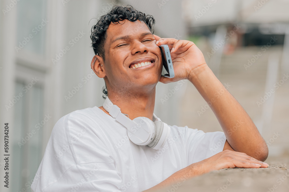 young latino man on the street talking on the mobile phone young latino man on the street talking on the mobile phone