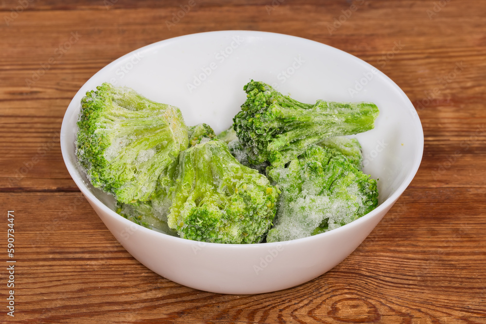 Frozen broccoli in white bowl on the rustic table Frozen broccoli in white bowl on the rustic table