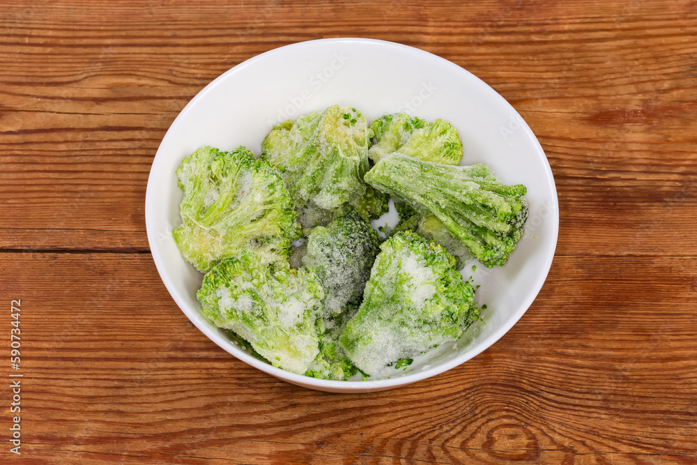 Frozen broccoli in white bowl on the rustic table Frozen broccoli in white bowl on the rustic table