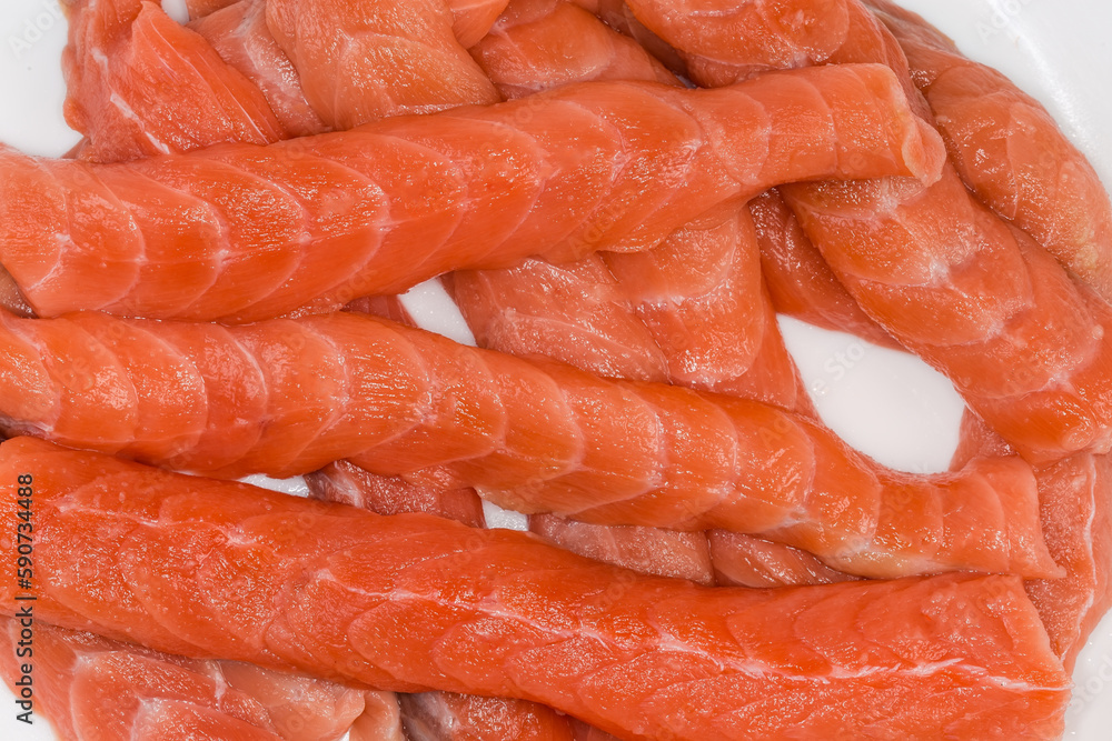Long slices of uncooked salmon, top view close-up Long slices of uncooked salmon, top view close-up