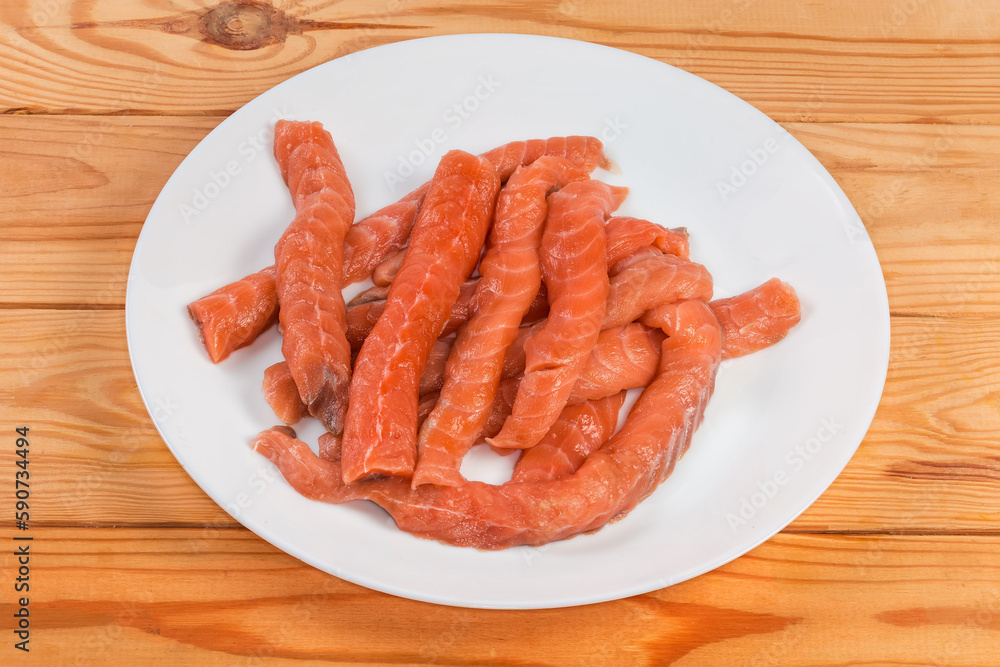 Long slices of uncooked salmon on the rustic table Long slices of uncooked salmon on the rustic table