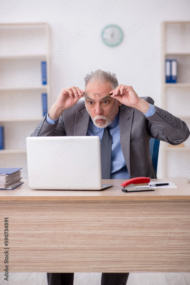 Old male employee working in the office Old male employee working in the office